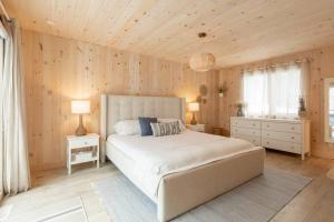 彻特西Chalet le Chardonnay - Spa , Foyers , Accès plage Lac-Jaune的卧室设有白色大床和木墙