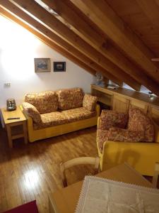 圣维托-迪卡多雷Deliziosa mansarda con vista Dolomiti的客厅配有沙发和桌子
