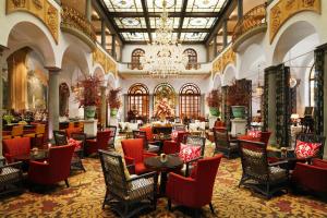 佛罗伦萨佛罗伦萨瑞吉酒店的酒店大堂设有桌椅和吊灯。