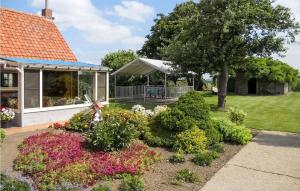 MerkemCozy Home In Merkem With Wifi的鲜花盛开的花园及凉亭