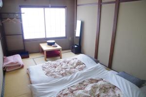 高山高山日式旅馆的一间医院间,配有一张床铺和一张桌子