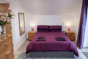 海尔Chy Lowen, great valley views from balcony的一间卧室配有一张紫色床、两个梳妆台和镜子