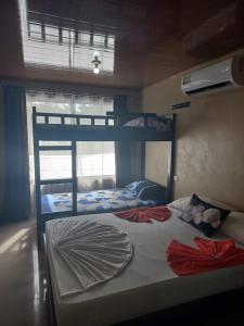 托尔图格罗Apartamentos Caimán Tortuguero的一间卧室设有两张双层床和一扇窗户。