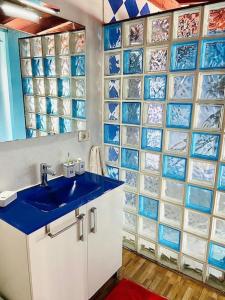 拉拉古纳Atico de la Pardela的浴室设有蓝色水槽和玻璃瓷砖墙