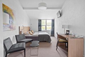 希勒勒Best Western Hotel Hillerød的一间卧室配有一张床、一张桌子和一把椅子