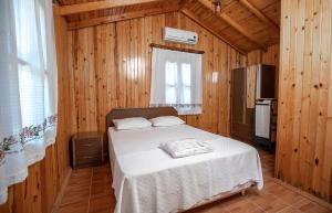 达特恰ÇUHADAR AHŞAP EVLERİ的木制客房内的一间卧室,配有一张床