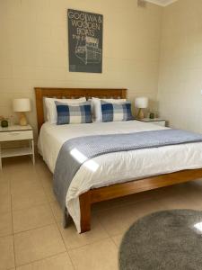 Hindmarsh IslandHideaway Tom’s on Mundoo Channel - Waterfront的一间卧室配有一张带蓝白色枕头的大床