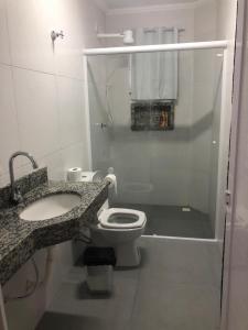 佩鲁伊比POUSADA COM PISCINA em PERUÍBE SABORES DA VIDA!!!的白色的浴室设有卫生间和水槽。