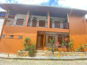帕拉蒂Samburá Paraty的一座橙色的建筑,阳台上种植了植物