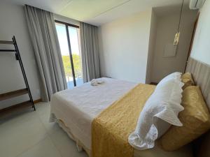 科斯塔萨乌佩Casa da Laguna - Costa do Sauipe的一间卧室设有一张床和一个大窗户