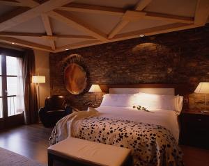艾因萨洛斯森特雷耶斯酒店的一间卧室设有一张带砖墙的大床