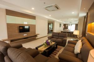 Kuala Belait花园中心酒店的客厅配有两张沙发和一台电视