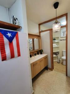 圣胡安Bee Inn Puerto Rico Charming Urban Apartment in San Juan的墙上有美国国旗的浴室