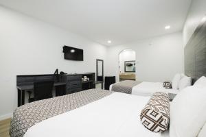 迪尔帕克Sapphire Inn & Suites的酒店客房配有两张床和一张书桌