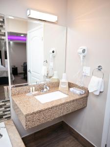 Bell贝尔钻石套房酒店的一间带水槽和大镜子的浴室