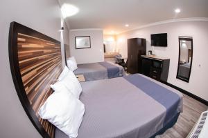 Bell贝尔钻石套房酒店的一间卧室配有一张大床和木制床头板