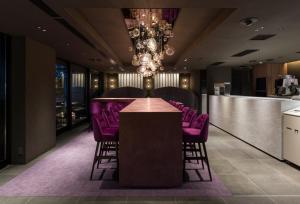 东京THE skM TOKYO HOTEL & DINING的一间会议室,配有紫色椅子和一间酒吧
