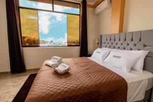 塔拉波托Sonqu Tarapoto的一间卧室设有一张大床和大窗户