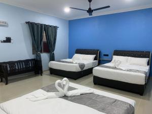 瓜埠VILLA TASIK TONGKANG KELI LANGKAWI的一间卧室设有两张床和蓝色的墙壁