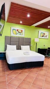 戈斯福德戈斯福德汽车旅馆的卧室设有一张位于绿色墙壁上的床铺