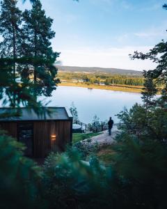 HektnerThe WonderInn Mirrored Glass Cabin - Wonderinn Delta的站在湖边小径上的人