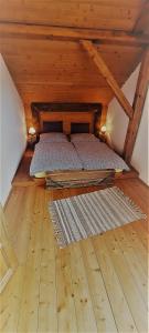 什特尔巴Podkrovie v zeleni - privat的木质阁楼内的一张床位,铺有木地板
