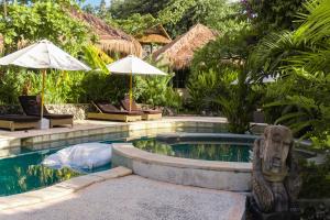 金巴兰Le Yanandra Bali Resort的毗邻度假酒店的带雕像的游泳池