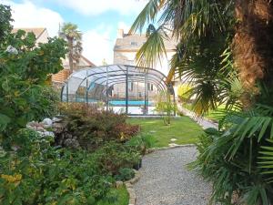 Le Manoir de KEROFIL的花园中的温室,带游泳池