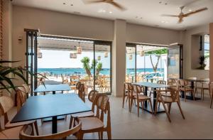 干尼亚弗里尼酒店 的一间带桌椅的餐厅,享有海滩美景