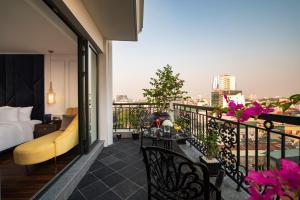 河内Soleil Boutique Hotel Hanoi的酒店客房设有带一张床的景观阳台。