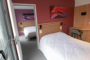 沃勒维克L'Orée des Sources的一间卧室配有两张床和镜子