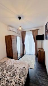 皮特什蒂Belle Apartments - Republicii的一间卧室设有一张床和一个大窗户