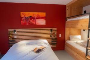 沃勒维克L'Orée des Sources的一间卧室设有两张双层床和红色的墙壁