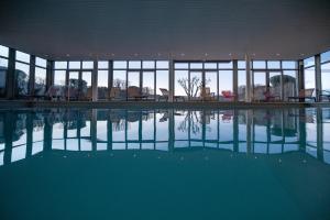格兰德拉维尔斯多麦娜杜瓦勒酒店的一座有窗户的建筑中的空游泳池