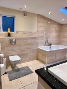 贝尔法斯特Ashfield Bed & Breakfast的带浴缸、卫生间和盥洗盆的浴室