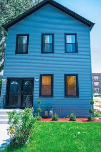 芝加哥Lux Apt in Bronzeville, Min from Downtown-RSV Now!的院子里设有黑窗的蓝色房子