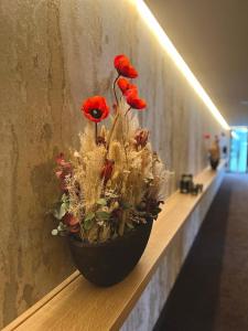 那慕尔Hotel Le 830 Namur的墙上装满红花的花瓶
