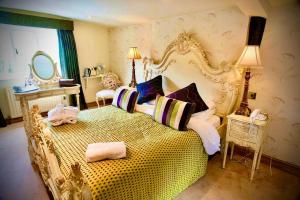 昂姆林Angmering Manor Hotel的一间卧室配有一张带枕头的大型黄色床