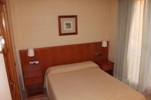 拉梅特拉·德·玛尔德尔波特酒店的一间小卧室,配有一张床和墙上的照片