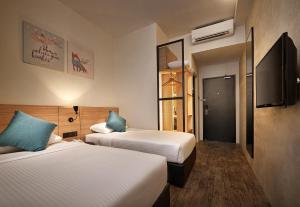峇六拜槟城优酒店的酒店客房设有两张床和一台平面电视。