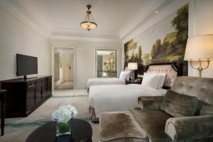即墨青岛海泉湾皇冠假日度假酒店的酒店客房,配有床和沙发