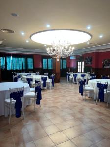 IniestaHOTEL LOS CAÑAS的宴会厅配有桌椅和吊灯