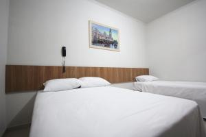 奥林匹亚奥林匹亚埃斯梅拉达旅馆的卧室配有两张床,墙上挂着一幅画