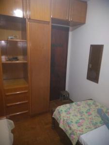 戈亚尼亚HOSTEL ECONÔMICO ELAs的一间卧室配有一张床和一个木制橱柜