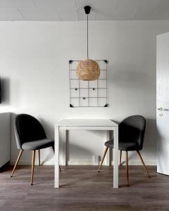 普赖斯特Kirsebærkroen - The Inn Between的客房内的一张白色桌子和两把椅子