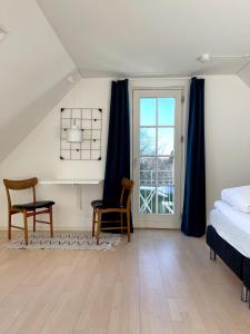 普赖斯特Kirsebærkroen - The Inn Between的一间卧室配有一张床、一张书桌和一个窗户。
