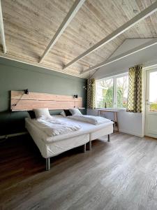 普赖斯特Kirsebærkroen - The Inn Between的一间卧室设有一张带木制天花板的大床