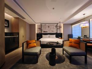 广州Arthur Hotel Luogang Guangzhou的一间卧室配有一张床、两把椅子和一张书桌