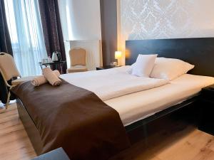 布拉迪斯拉发莫德纳酒店的卧室配有一张带白色床单和枕头的大床。
