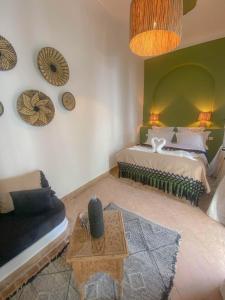 马拉喀什Riad Dar Marrakcha的一间卧室配有一张床、一张沙发和一张桌子